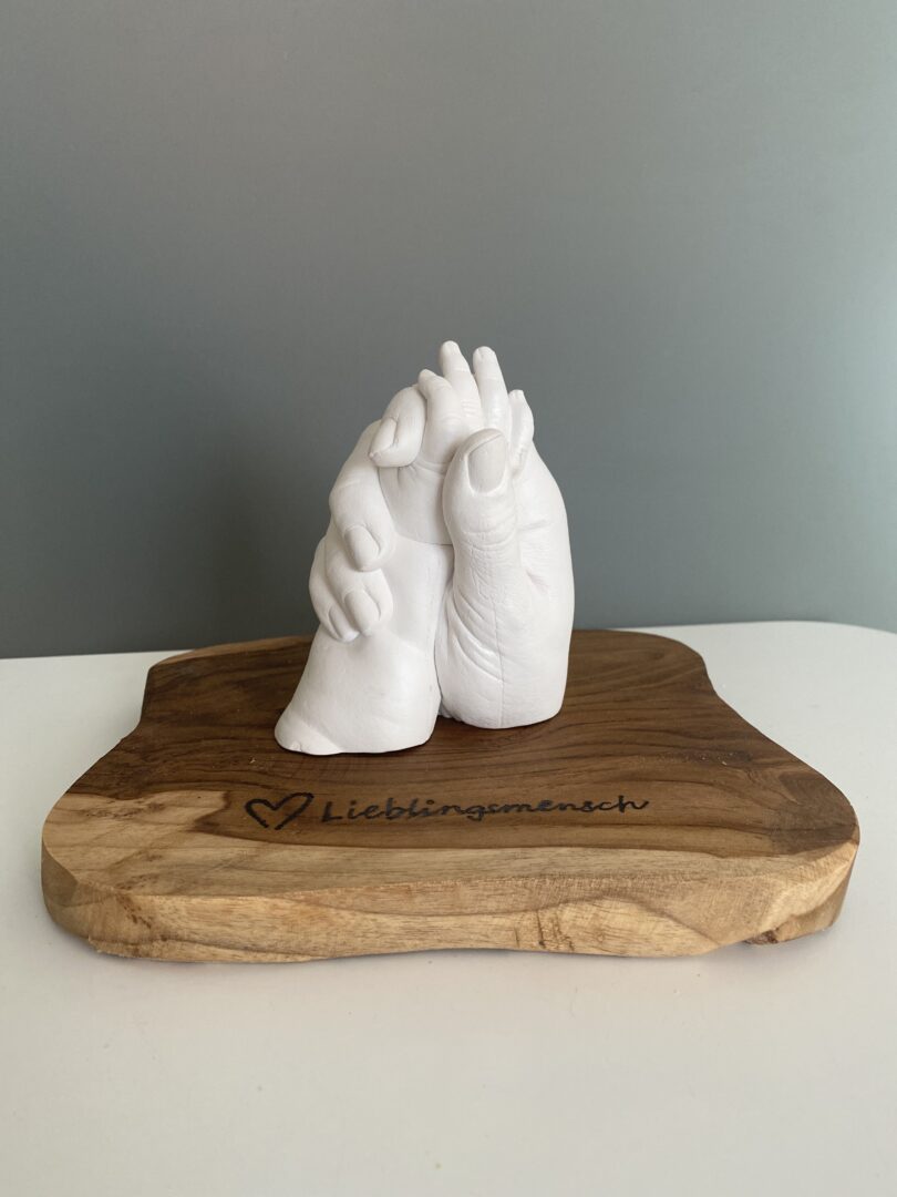 Mama und Baby Handabdruck als detailgetreue Gipsabformung auf einem Holzsockel