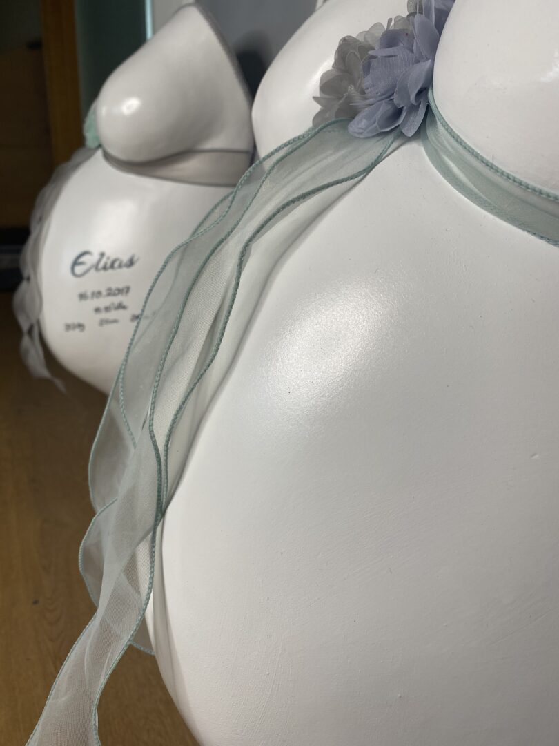Detailansicht von zwei Babybauch-Gipsabdrücken von zwei Brüdern