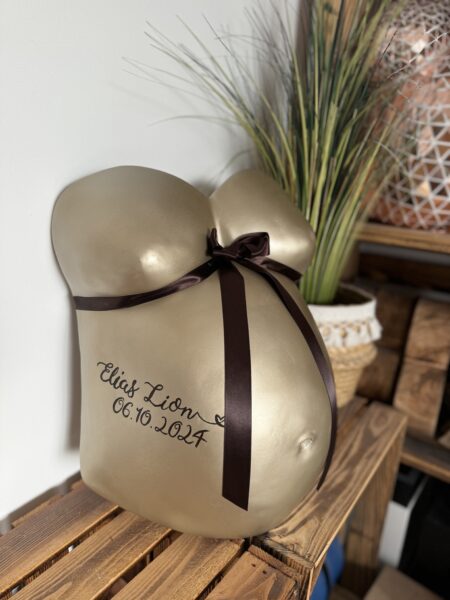 goldener Babybauch Gipsabdruck aus München mit individueller Beschriftung und Dekoration