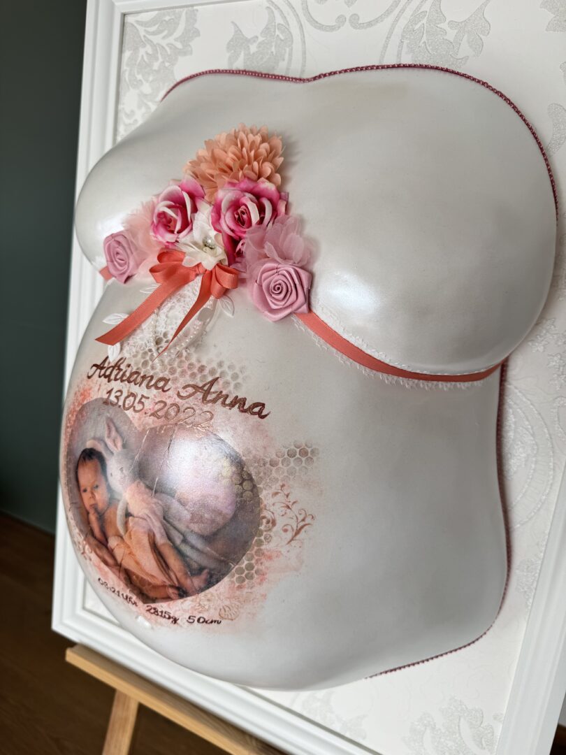 Babybauch-Gipsabdruck mit floralem Schmuck, Schleife und integriertem Babyfoto