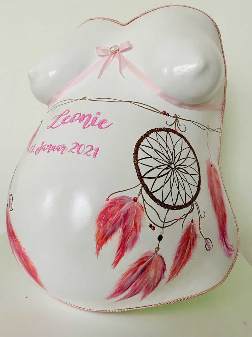 Babybauch Gipsabdruck mit Traumfänger-Motiv und rosa Federn