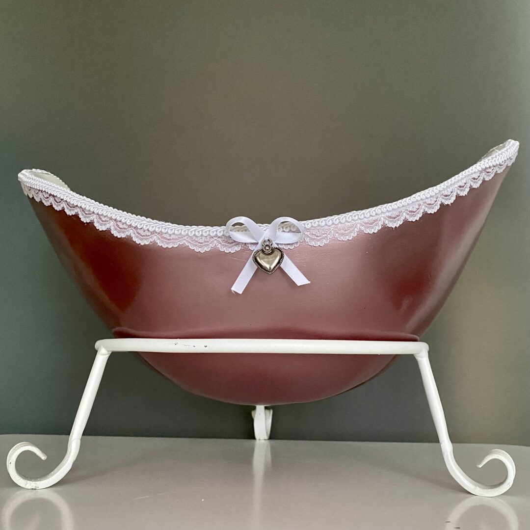 Belly Bowl als individuell gestaltete Babybauchschale in Rosé mit weißer Spitzenverzierung und Herzanhänger