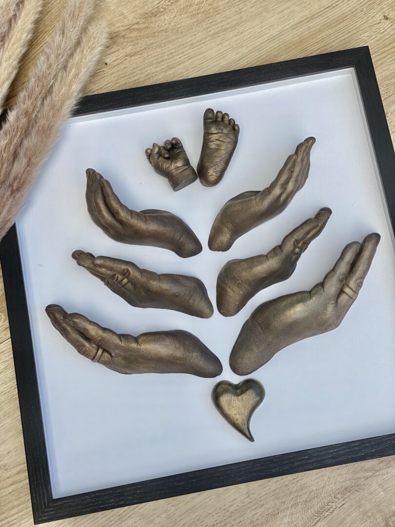 Familienabdruck im Bilderrahmen mit detailgetreuen Gipsabformungen von Händen sowie einer Babyhand und einem Babyfuß
