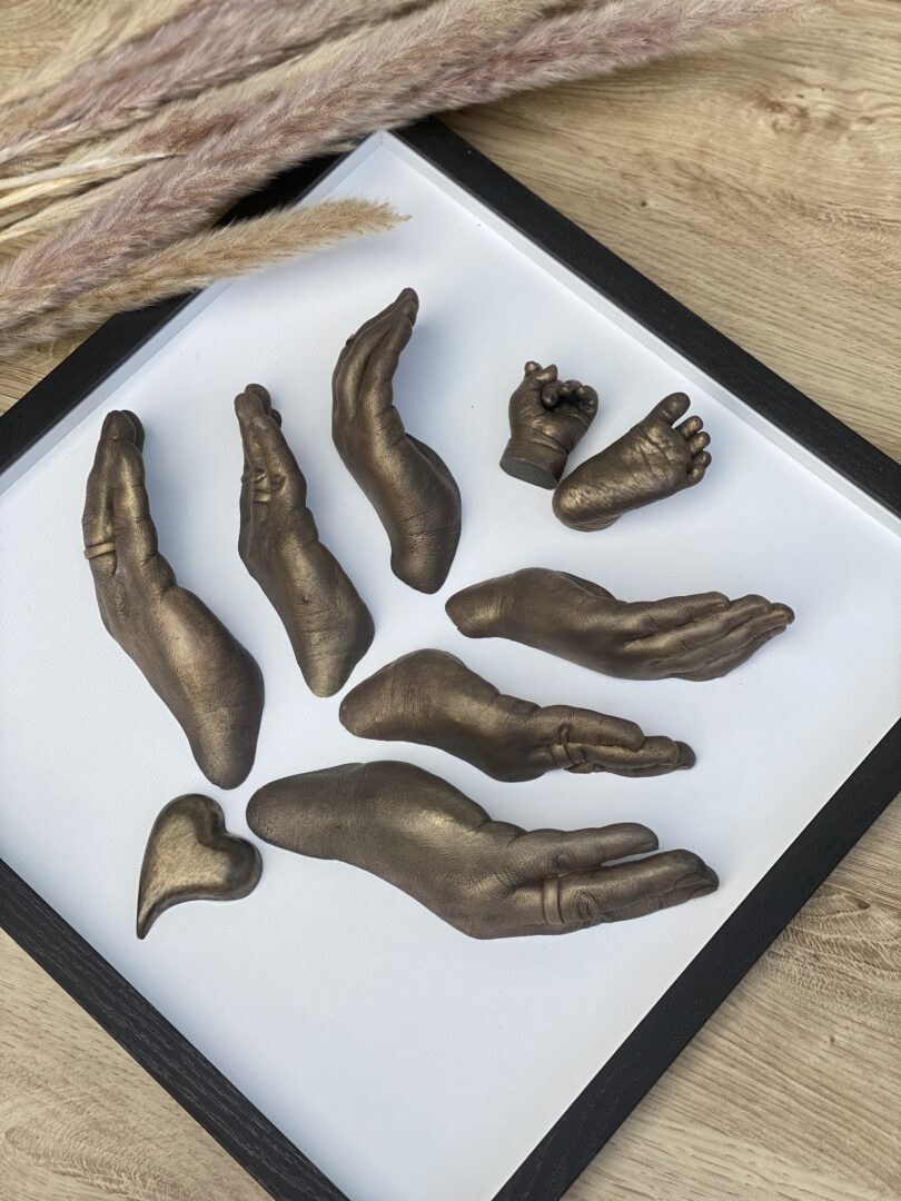 Detailaufnahme eines Familienabdrucks mit den Gipsabformungen von Mama, Papa und zwei Kindern