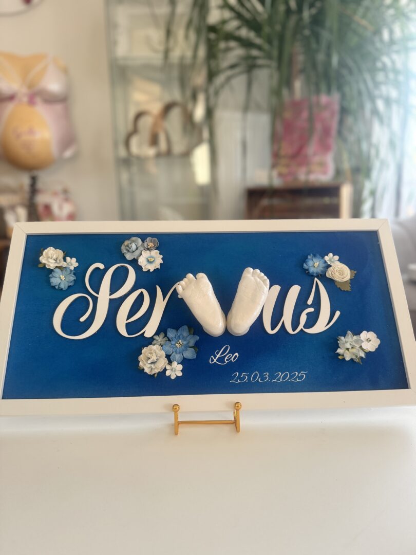 Gipsabdruck Babyfüße zur Geburt in einem blauen Bilderrahmen mit Blumen