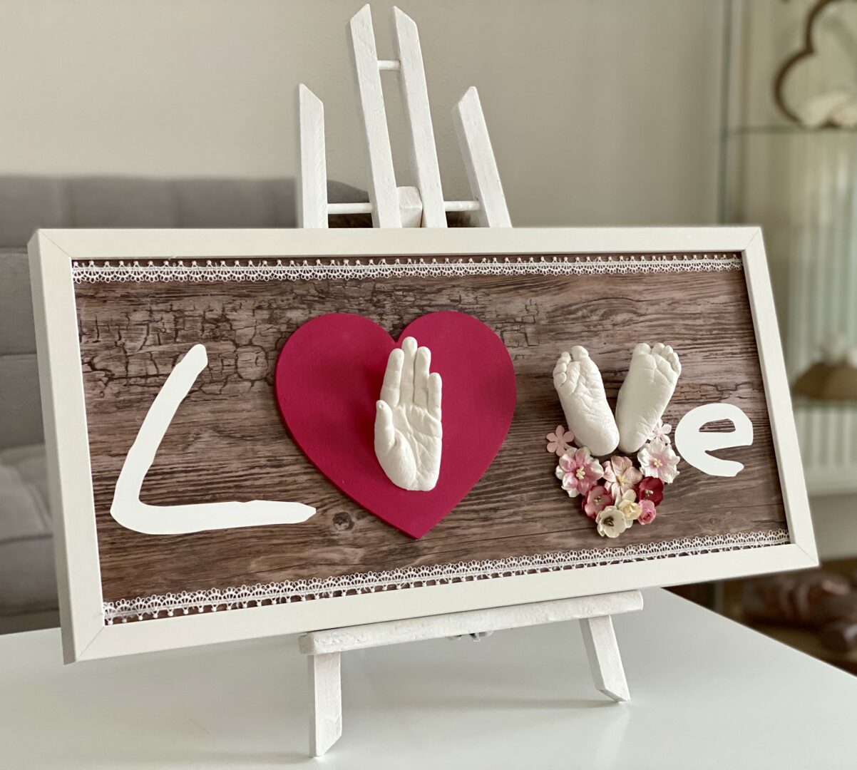 Gipsabdruck Geschwister – Babyfüße und Hand der großen Schwester im LOVE Bilderrahmen