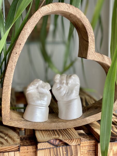 Babyhände als detailgetreuer Gipsabdruck in einem Holzherz