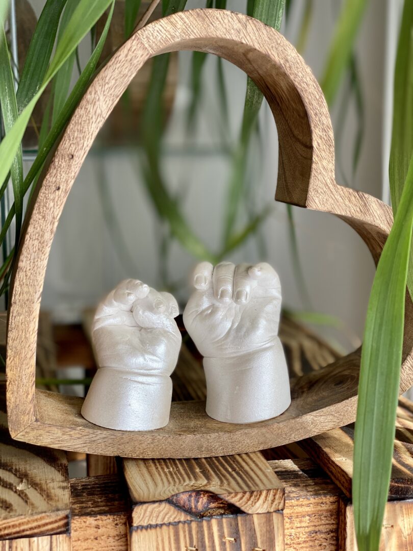 Babyhände als detailgetreuer Gipsabdruck in einem Holzherz