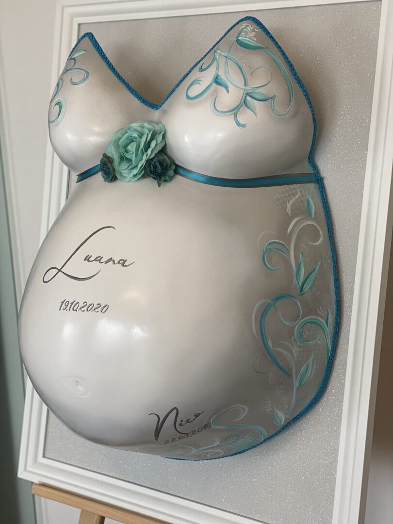 Klassisch veredelter Babybauch Gipsabdruck mit blauen Ornamenten, Blumenverzierung und persönlicher Beschriftung