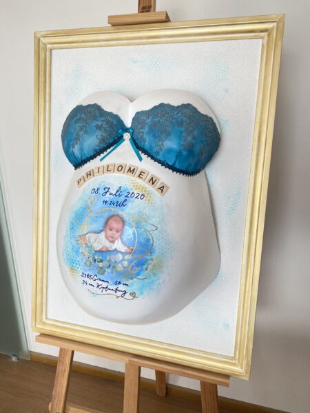 Babybauch-Gipsabdruck mit blauem BH-Design, Babyfoto und goldfarbenem Rahmen