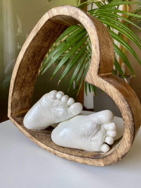 Babyfüße als detailgetreue Gipsabformung in einem handgefertigten Holzherz