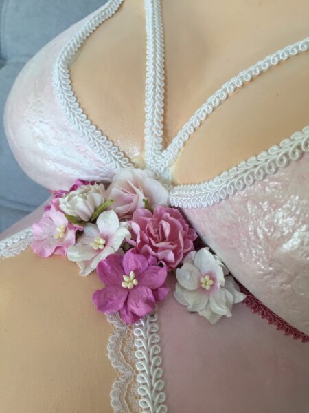 Detailansicht eines Babybauchabdrucks mit BH-Optik, Spitzenverzierung und Blumen
