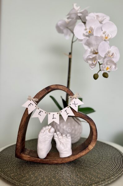 Babyhand und Babyfuß als detailgetreue Gipsabdrücke in einem natürlichen Holzherz